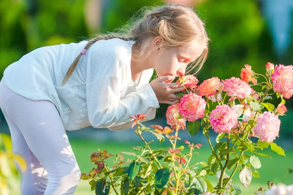 Niña adorable oliendo flores coloridas al aire libre — Foto de Stock