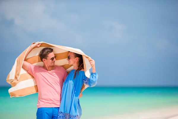 Joven familia feliz durante las vacaciones en la playa tropical —  Fotos de Stock