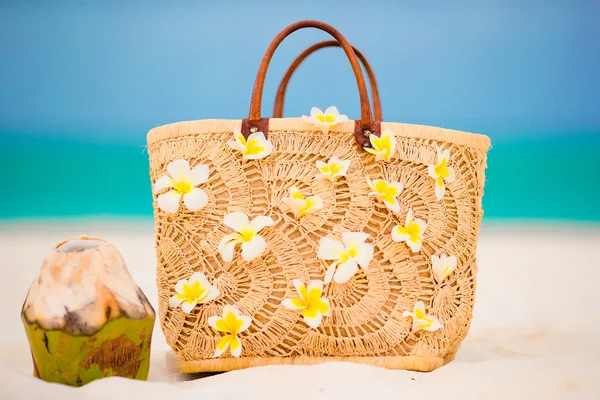 Primer plano hermoso bolso con flores de frangipani y coco en la playa blanca —  Fotos de Stock