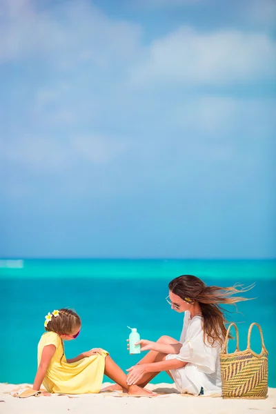 Little adorable girl applying sun cream to her mother nose — Stock Photo, Image