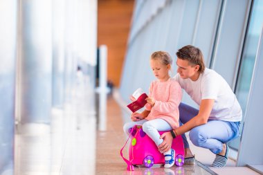 Mutlu aile Bagaj ve yatılı için bekleyen Havaalanı'nda biniş kartı