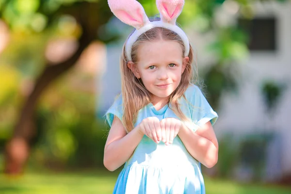 Adorable little girl wearing bunny ears with Easter eggs on spring day — Stock Photo, Image