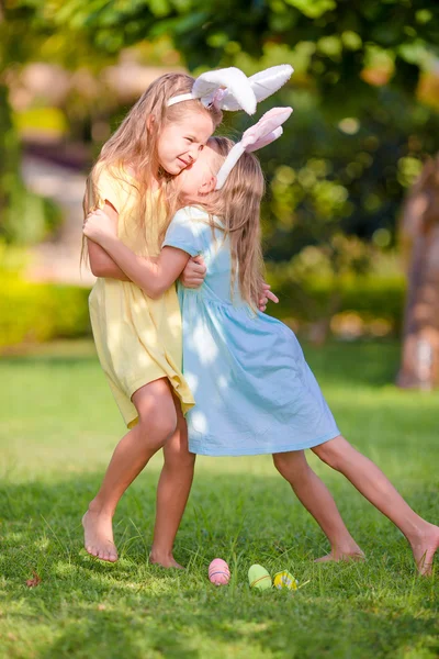 Two adorable little sisters wearing bunny ears on Easter day outdoors — Stock Photo, Image
