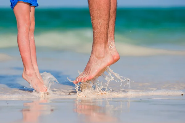 Zbliżenie dziecko i dorosły stóp na białej, piaszczystej plaży — Zdjęcie stockowe