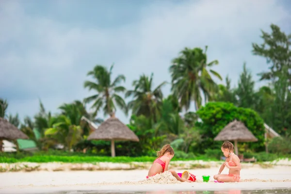 Adorable little girls playing with toys during beach vacation — Stock Photo, Image