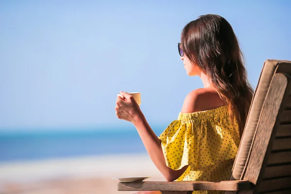 Young woman drinking coffee cappuccino enjoying beach view — Stock Photo, Image