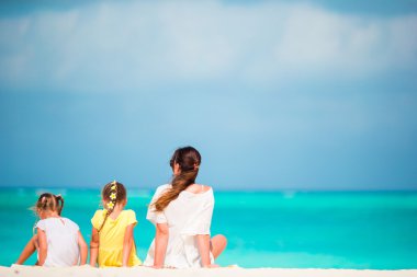 Tatlı küçük kızlar ve genç anne tropikal beyaz plajda