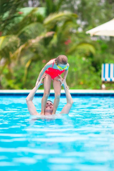 Klein meisje en gelukkig vader hebben plezier samen in buitenzwembad — Stockfoto