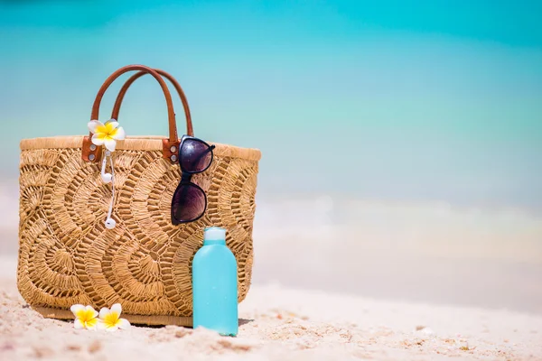 Plaj aksesuarları - hasır çanta, kulaklık, şişe krem ve sahilde güneş gözlüğü — Stok fotoğraf