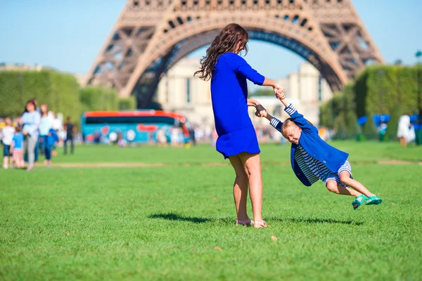 Boldog anya és a kis aranyos lány jó szórakozást a párizsi Eiffel-torony közelében — Stock Fotó