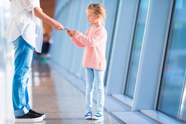 Mother and little girl with boarding pass at airport waiting the flight — Stock Photo, Image