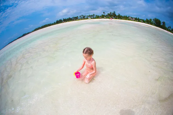 Adorabile bambina che gioca con i giocattoli durante le vacanze al mare — Foto Stock