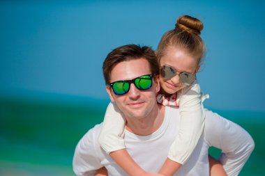 Mutlu baba ve onun sevimli küçük kızı tropik sahilde eğleniyorlar.