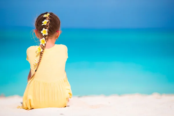 Adorable little girl with frangipani flowers in hairstyle on beach — Stock Photo, Image
