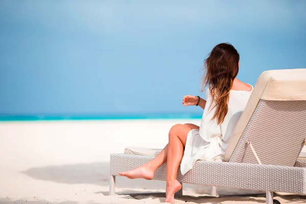 年轻的女子在与手机在沙滩的躺椅 — 图库照片