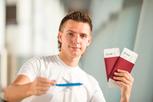 Young man with small airplane in airport waiting his flight — Stock Photo, Image