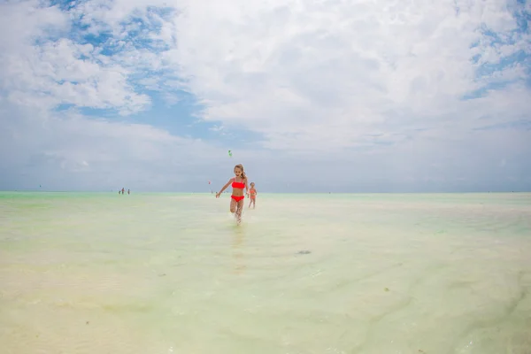 Little girls having fun at tropical beach during summer vacation playing together at shallow water — Stock Photo, Image