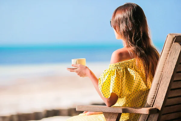 Mujer feliz bebiendo café capuchino disfrutando de la vista a la playa — Foto de Stock