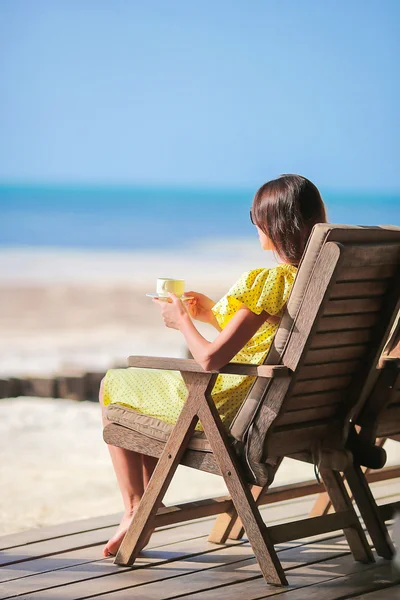 Gelukkige vrouw, drinken koffie cappuccino genieten van uitzicht op het strand — Stockfoto