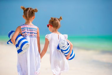 Tropikal plajda havlu ile sevimli küçük kızlar