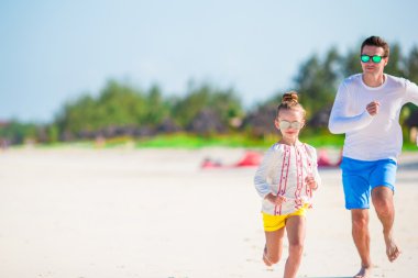 Küçük kız ve genç babası tropikal plajda eğlenmek