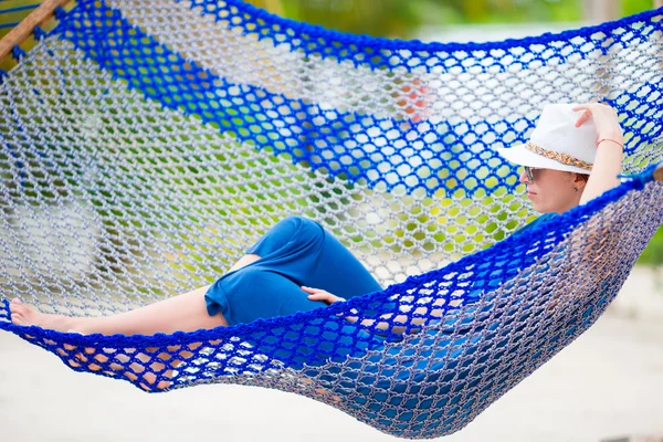 Hermosa mujer relajándose en la hamaca en la playa tropical — Foto de Stock