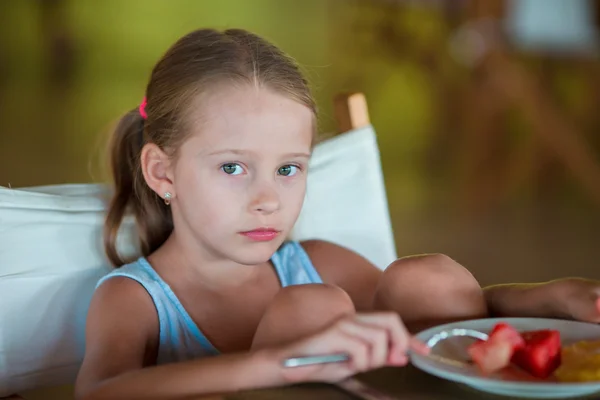 Adorable little girl having breakfast in outdoor cafe — Stock Photo, Image
