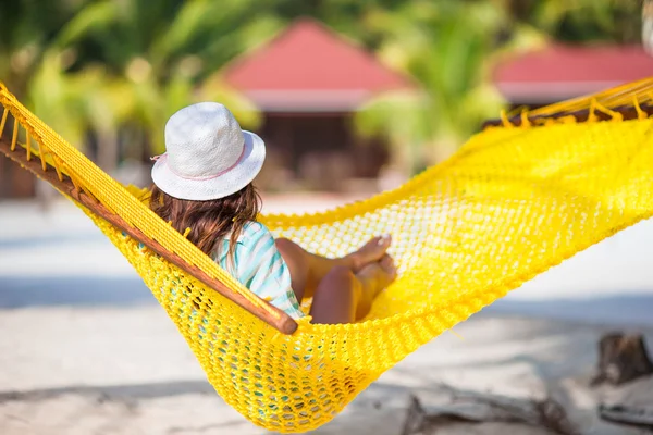 Beautiful girl relaxing at hammock on white beach — Stock Photo, Image