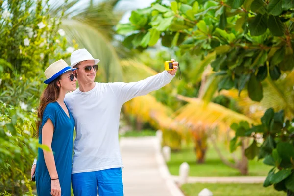 Joven pareja feliz haciendo selfie con teléfono móvil en vacaciones tropicales —  Fotos de Stock