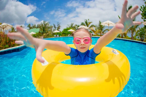 Retrato da criança feliz com círculo de borracha inflável que se diverte na piscina — Fotografia de Stock