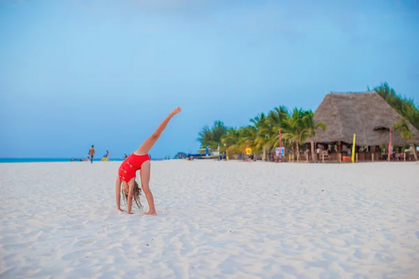 Schattig meisje, plezier maken Radslag op tropisch strand bij zonsondergang — Stockfoto