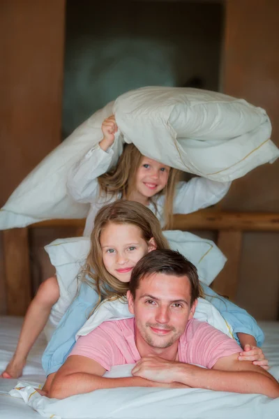 Padre con dos adorables niñas divirtiéndose en la cama — Foto de Stock