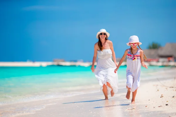 Gelukkige familie van moeder en meisje op witte strand — Stockfoto