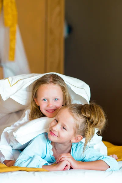 Adorable little girls having fun at bed inside — Stock Photo, Image