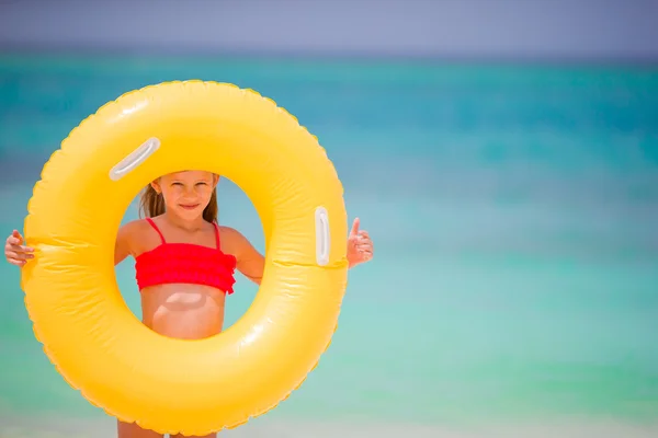 Schattig meisje met opblaasbare rubberen cirkel op witte strand — Stockfoto