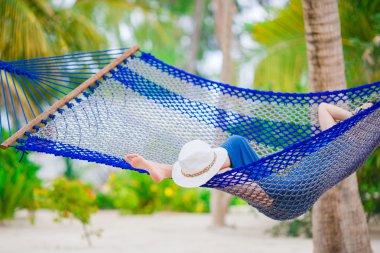Closeup hasır plaj şapka hamakta rahatlatıcı genç kadın yakınındaki