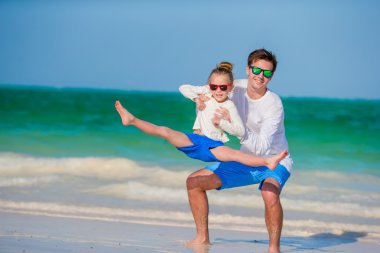 Mutlu aile beyaz tropik sahilde eğleniyor