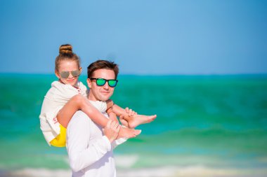 Mutlu aile beyaz tropik sahilde eğleniyor