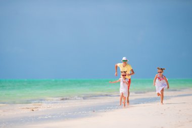 mutlu baba ve sevimli küçük kızları tropikal plaj