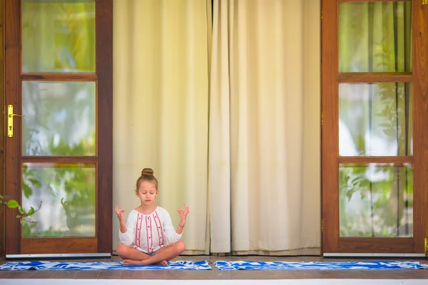 Küçük kız terasta yoga egzersizi yapıyor. — Stok fotoğraf