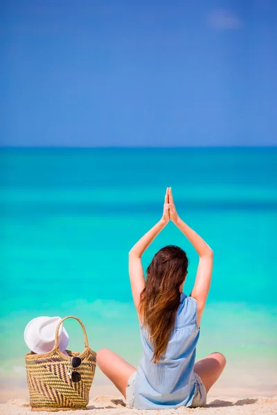 Rilassato giovane donna che pratica yoga all'aperto sulla spiaggia bianca — Foto Stock