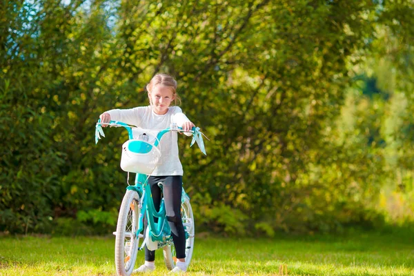 Adorable girl riding a bike at beautiful summer day outdoors — Stock Photo, Image