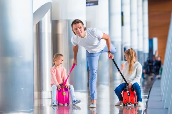 Familia feliz con dos niños en el aeropuerto se divierten esperando el embarque —  Fotos de Stock