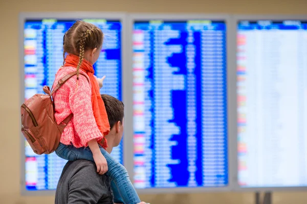 Liten jente med farens bakgrunnsinformasjon på flyplassen – stockfoto