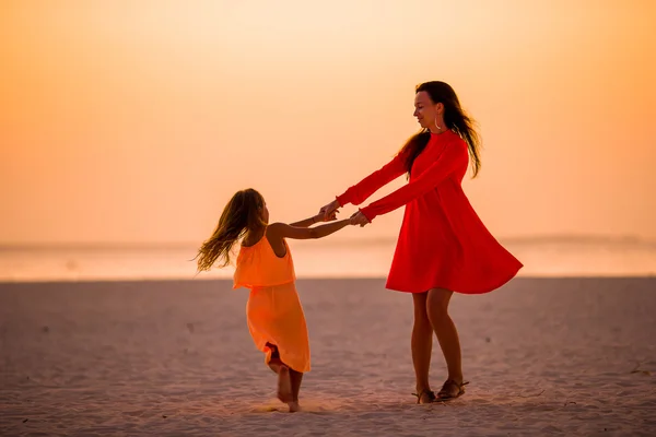 Glückliche Mutter mit kleinem Mädchen, die am Abend Spaß am Strand hat — Stockfoto