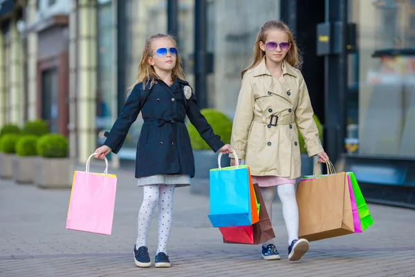 Adorables niñas en las compras. Retrato de niños con bolsas de compras . — Foto de Stock