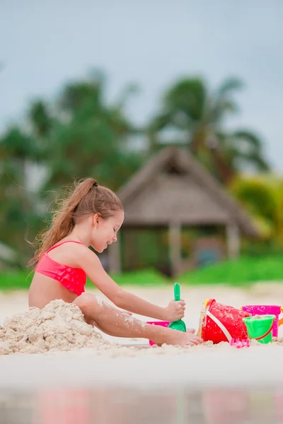 Adorabile bambina che gioca con i giocattoli sulla spiaggia — Foto Stock