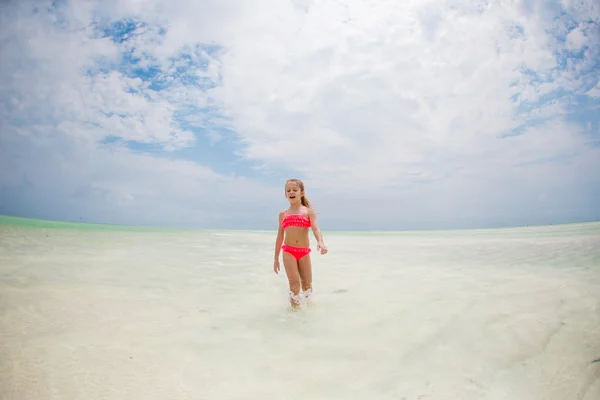 Adorabile bambina divertirsi sulla spiaggia tropicale durante le vacanze — Foto Stock