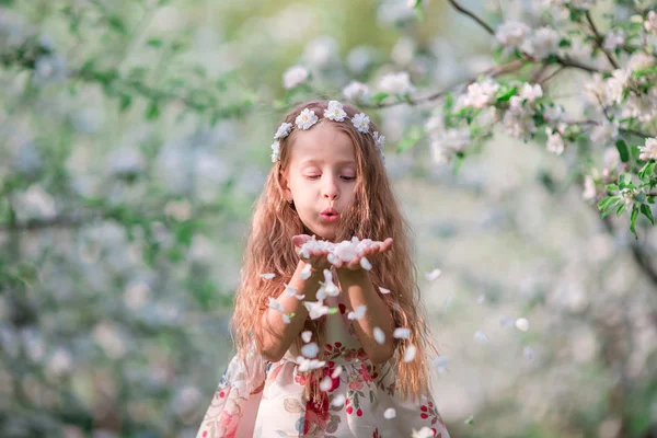 Adorabile bambina nel giardino di ciliegi in fiore il giorno di primavera — Foto Stock