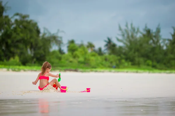 Adorabile bambina che gioca con i giocattoli sulla spiaggia — Foto Stock